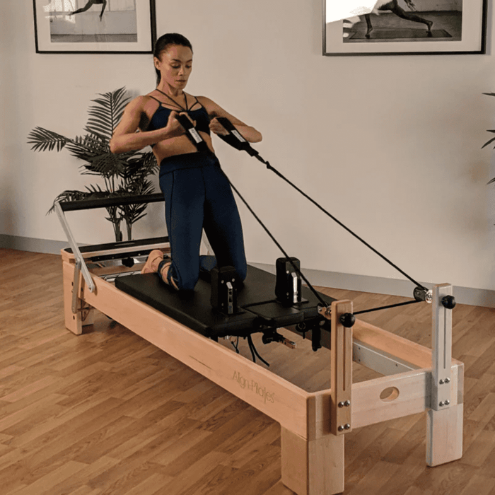 align pilates m8 pro wood reformer user exercising